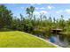 Private backyard with a wooden boardwalk along a canal and lush landscaping at 10300 Pocket Ln, Orlando, FL 32836