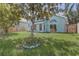 Exterior view from backyard of an aqua colored home, with windows and a privacy fence at 10599 Satinwood Cir, Orlando, FL 32825