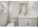 Bathroom featuring a white vanity, quartz countertop, toilet, and a unique round window at 10599 Satinwood Cir, Orlando, FL 32825