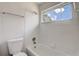 Bathroom featuring a tiled tub and shower, with a window allowing natural light at 10599 Satinwood Cir, Orlando, FL 32825