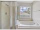 Bright bathroom showcasing a shower and separate bath tub in an updated space at 10599 Satinwood Cir, Orlando, FL 32825