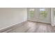 Bedroom with hard surface flooring and two large windows with views of the property grounds at 10599 Satinwood Cir, Orlando, FL 32825
