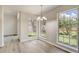 Sunlit dining area featuring modern flooring, a stylish chandelier, and multiple windows with backyard views at 10599 Satinwood Cir, Orlando, FL 32825