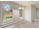 Sunlit dining area featuring modern flooring, a stylish chandelier, and multiple windows with backyard views at 10599 Satinwood Cir, Orlando, FL 32825
