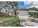 Two-story home featuring an attached two-car garage and mature trees in a manicured front yard at 10599 Satinwood Cir, Orlando, FL 32825