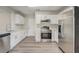 Modern kitchen with stainless steel appliances, white cabinets, and wood-look flooring at 10599 Satinwood Cir, Orlando, FL 32825