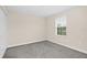 This bedroom has wall-to-wall gray carpeting and a large window for natural light at 11139 Cyrilla Woods Dr, Orlando, FL 32832