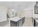 Modern kitchen island with a sink, dishwasher, and stainless-steel appliances with tile floor at 11139 Cyrilla Woods Dr, Orlando, FL 32832