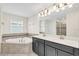Luxurious main bathroom with double sinks, a soaking tub, and a separate glass-enclosed shower at 11139 Cyrilla Woods Dr, Orlando, FL 32832