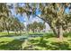 Playground area with swing sets and picnic tables, surrounded by mature trees, offering a shaded and tranquil environment at 11139 Cyrilla Woods Dr, Orlando, FL 32832
