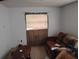 This living room has tiled flooring, and a covered window, with a brown couch and small coffee table at 1152 Ring St, Deltona, FL 32725