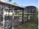 View of caged pool needing maintenance, overlooking the backyard with mature trees, providing a private and serene setting at 1152 Ring St, Deltona, FL 32725