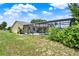 View of the home's backyard, showing the screened-in pool area and lush lawn from a low angle at 1165 Indian Ridge E Trl, Kissimmee, FL 34747
