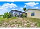 Spacious backyard featuring a screened-in lanai, outdoor patio furniture, and lush greenery at 1165 Indian Ridge E Trl, Kissimmee, FL 34747