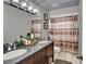 Bathroom featuring a double sink vanity with dark cabinets, granite countertop, and decorative mirror at 1165 Indian Ridge E Trl, Kissimmee, FL 34747