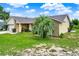 Single story home with a well manicured lawn and a mature palm tree in the front yard at 1165 Indian Ridge E Trl, Kissimmee, FL 34747