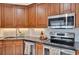 Kitchen featuring wooden cabinets, stainless steel appliances, and granite countertops at 1165 Indian Ridge E Trl, Kissimmee, FL 34747