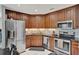 Kitchen featuring wooden cabinets, stainless steel appliances, and granite countertops at 1165 Indian Ridge E Trl, Kissimmee, FL 34747
