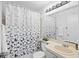 Bathroom with a floral shower curtain, mirror, sink and vanity with decorative lighting at 126 Spanish Moss Ct, Orlando, FL 32828