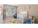 Bright Bedroom with white crib, colorful rug, and a comfortable rocking chair at 12868 Holdenbury Ln, Windermere, FL 34786
