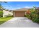 Two car garage and driveway surrounded by lush plants and trees at 12868 Holdenbury Ln, Windermere, FL 34786