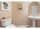Charming powder room with pedestal sink, framed mirror, and framed artwork at 12868 Holdenbury Ln, Windermere, FL 34786
