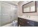 Updated bathroom with a dark wood vanity, white marble countertop, and a shower with sliding glass doors at 1301 Winter Green Way, Winter Garden, FL 34787