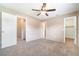 Neutral bedroom with carpet, ceiling fan, and doorways leading to closets and other rooms at 1301 Winter Green Way, Winter Garden, FL 34787