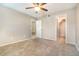 Bedroom featuring neutral carpet, a ceiling fan, and access to a private bathroom and closet at 1301 Winter Green Way, Winter Garden, FL 34787