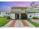 Charming townhome with a green tile roof, brick-lined driveway, and lush front yard at 1301 Winter Green Way, Winter Garden, FL 34787