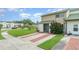 Charming townhome with a green tile roof, lush front yard, and brick-lined driveway at 1301 Winter Green Way, Winter Garden, FL 34787