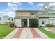 Charming townhome with a green tile roof, brick-lined driveway, and lush front yard at 1301 Winter Green Way, Winter Garden, FL 34787