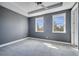 Gray bedroom with neutral carpet, tray ceiling, and two large windows at 14088 Tarvin St, Orlando, FL 32832