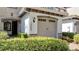 View of townhome garage with stone detail and manicured bushes at 14088 Tarvin St, Orlando, FL 32832