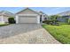 Charming single-Gathering home featuring a two-car garage, paver driveway, and well-maintained landscaping at 1430 Challenger Ave, Davenport, FL 33897