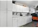Garage features epoxy floors, ample cabinetry, and a large countertop for working at 1430 Challenger Ave, Davenport, FL 33897