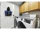 Well-lit laundry room with modern washer and dryer, storage cabinets, and a convenient countertop at 1430 Challenger Ave, Davenport, FL 33897