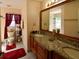 Bathroom featuring a double sink vanity with a granite countertop and a large mirror at 1436 Swan Ct, Kissimmee, FL 34759