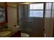 Bathroom featuring a tiled shower with a window, a vanity with a granite countertop, and a toilet at 1436 Swan Ct, Kissimmee, FL 34759