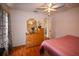 Bedroom featuring hardwood floors, a ceiling fan, and a bureau with a mirror on top at 1436 Swan Ct, Kissimmee, FL 34759