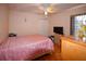 Bedroom featuring hardwood floors, a ceiling fan, a closet with folding doors, and a large pink bed at 1436 Swan Ct, Kissimmee, FL 34759
