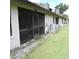 Back exterior of home featuring a screened-in porch and well-maintained landscaping at 2480 Tahoe Cir # 2480, Winter Park, FL 32792