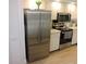Modern kitchen with stainless steel refrigerator, white cabinets, and updated appliances at 2480 Tahoe Cir # 2480, Winter Park, FL 32792