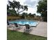 Community pool with chairs and tables on a beautiful day at 2480 Tahoe Cir # 2480, Winter Park, FL 32792