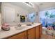 Bright bathroom with dual sinks, wooden cabinets, and a fun, beach-themed shower curtain at 2507 Water Valley Dr, St Cloud, FL 34771