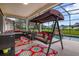 Covered patio features a comfortable swing, outdoor seating, and a view of the pool at 2507 Water Valley Dr, St Cloud, FL 34771