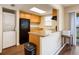 Compact kitchen featuring wood cabinets, black appliances, and a convenient washer/dryer setup at 2791 L B Mcleod Rd # C, Orlando, FL 32805