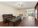 Open living room with a brown leather couch, a gray armchair, and sliding doors to a balcony at 2791 L B Mcleod Rd # C, Orlando, FL 32805