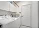 Functional laundry room with washer, dryer, cabinets, and a rod for hanging clothes at 280 Bay St, Apopka, FL 32712