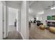 Open-concept living room with lots of light, wood-look floors, with hallway to the bedrooms at 280 Bay St, Apopka, FL 32712
